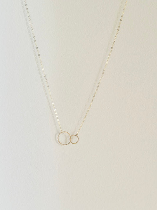 Double link circle pendant necklace, styled on a white tray