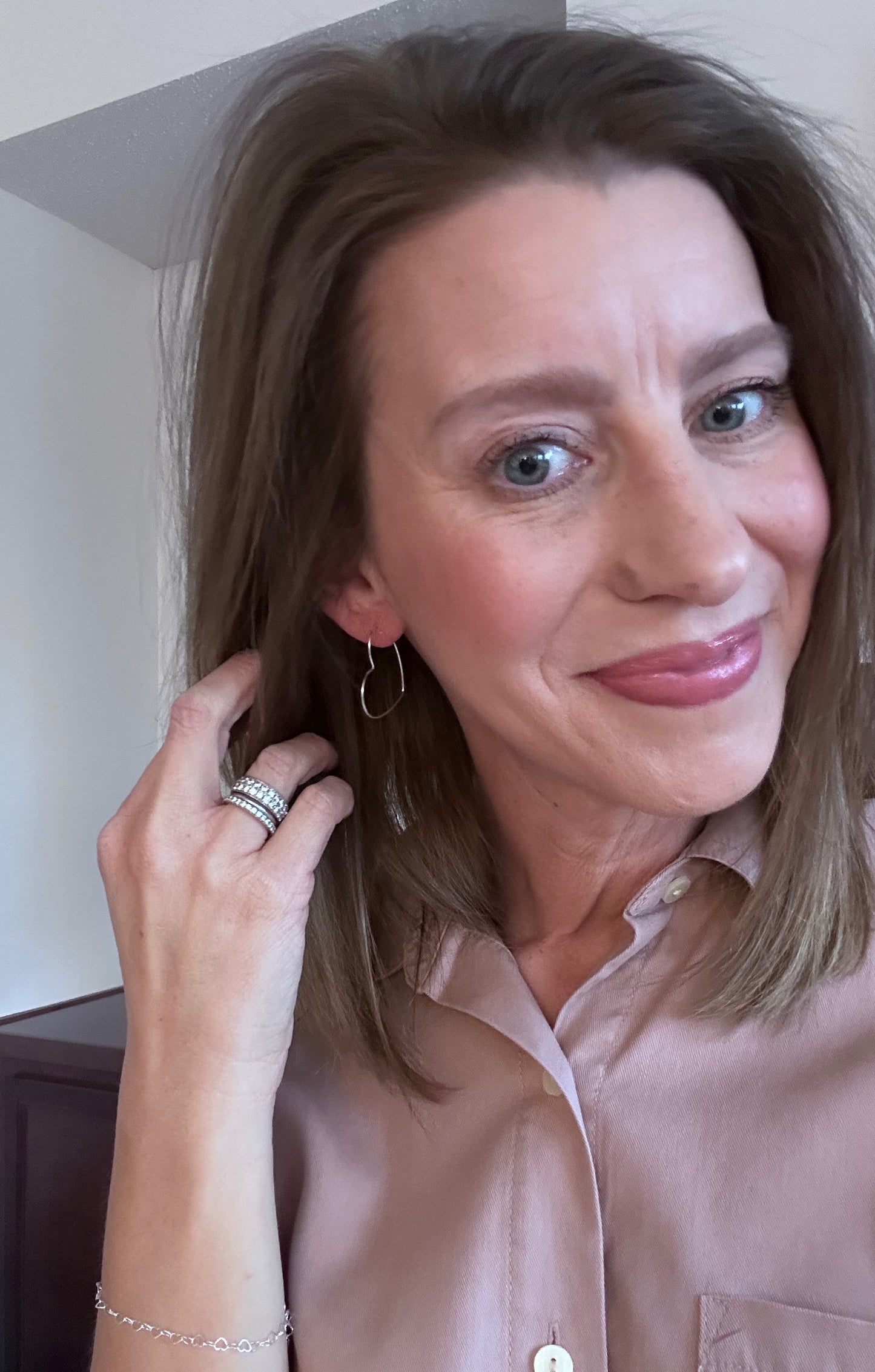 heart shaped hoop earring on woman's ear