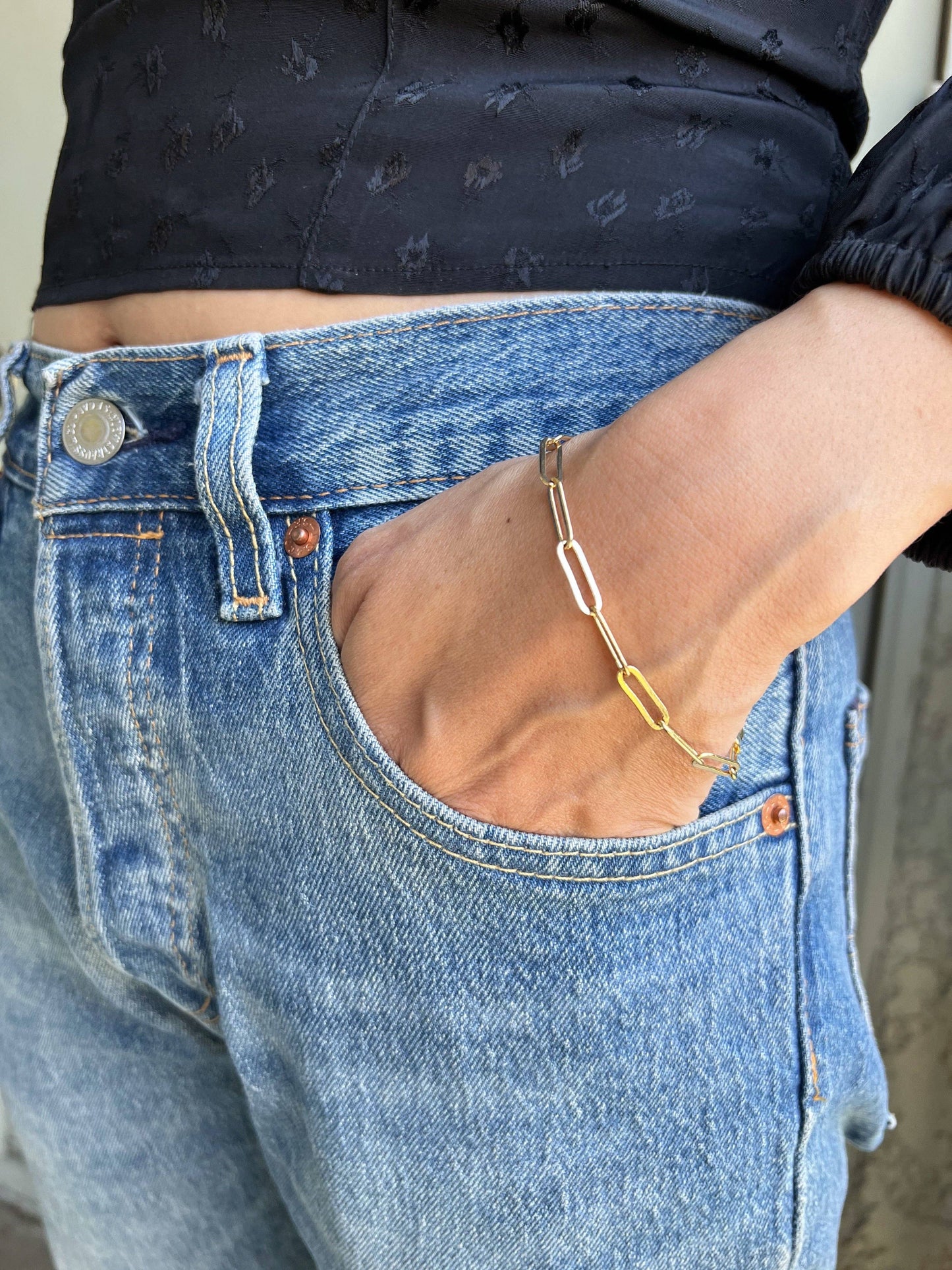 18k gold paperclip bracelet close up shot on a woman's wrist