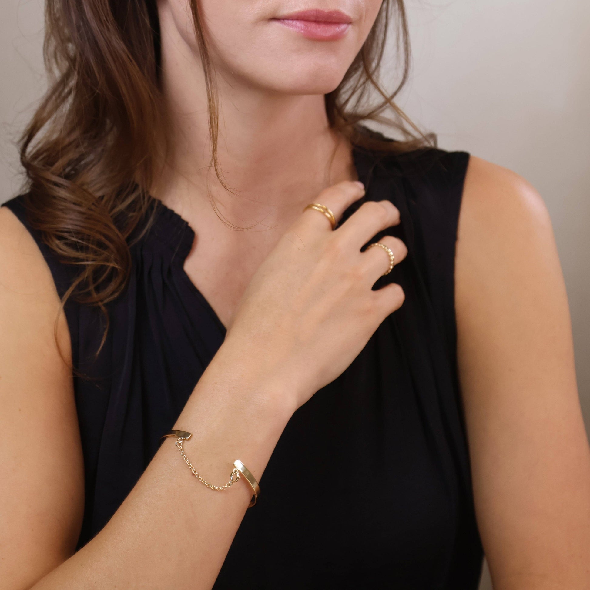 Woman wearing 18k gold filled bangle with chain