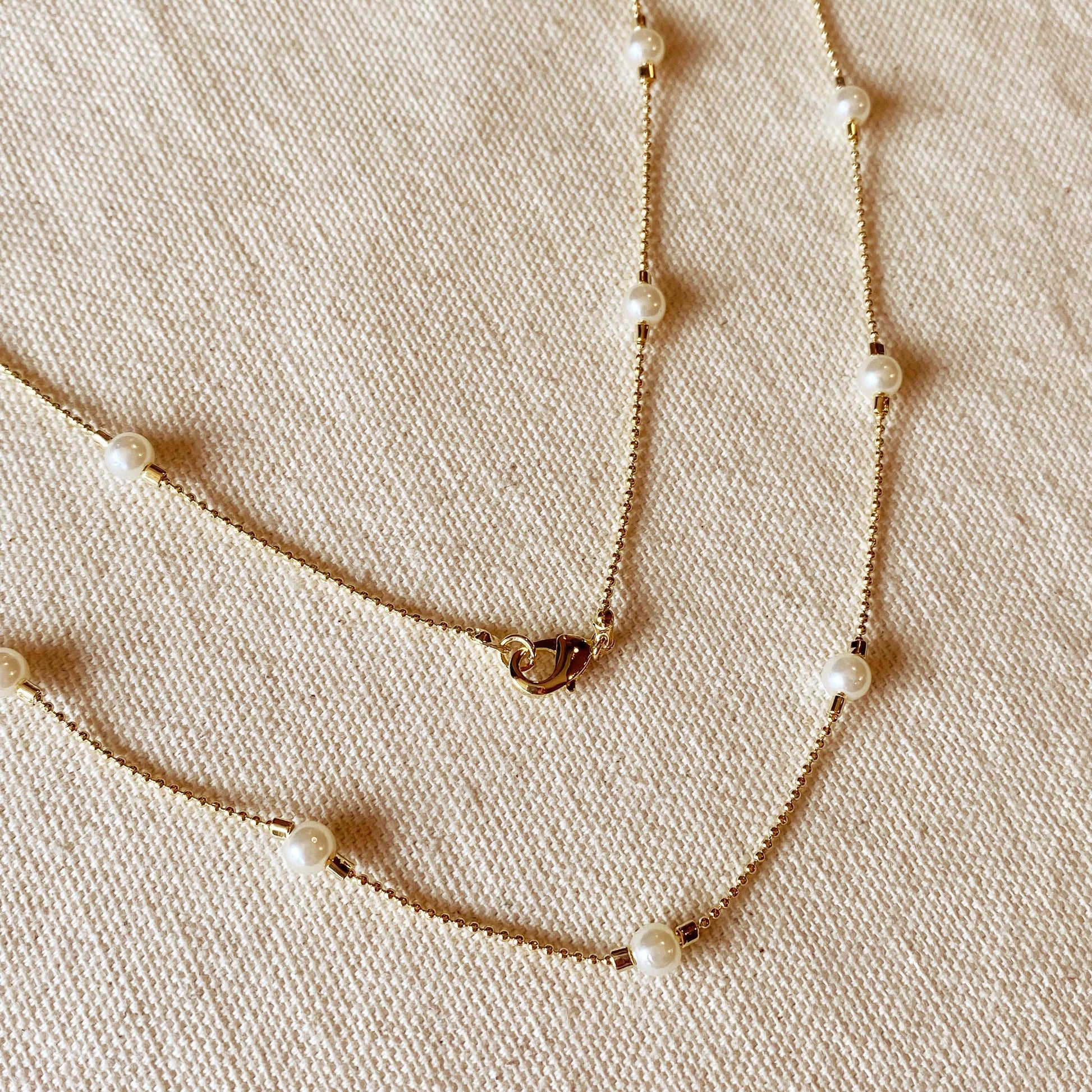 Close up of long wrap around pearl necklace featuring 18k gold filled chain and lobster clasp