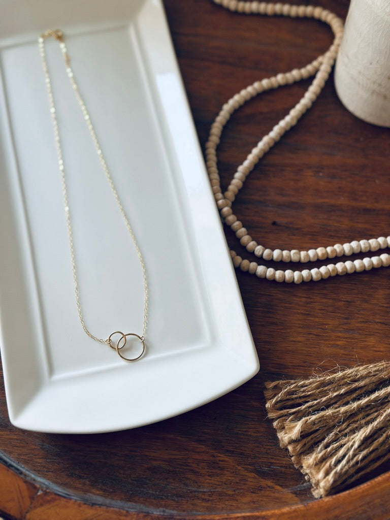 Double link circle pendant necklace, styled on a white tray