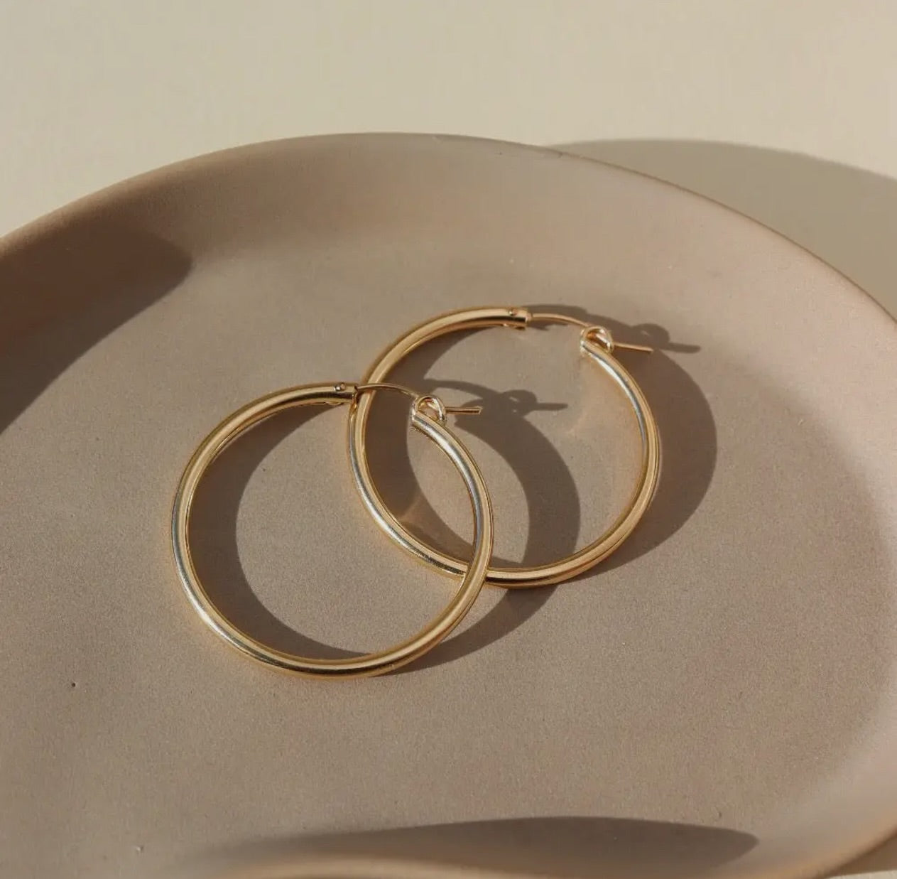 14k Gold hoop earrings laying in a jewelry tray