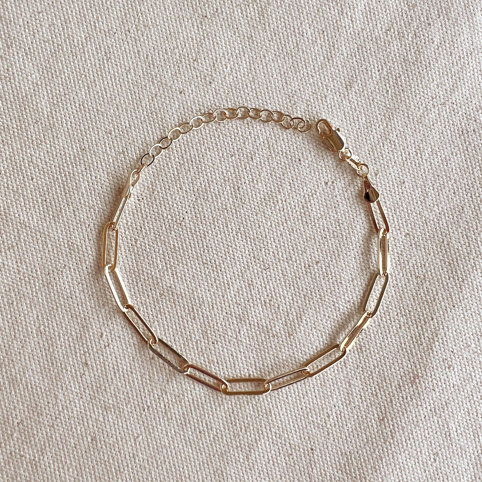 minimalist gold paperclip bracelet layering jewelry flat lay