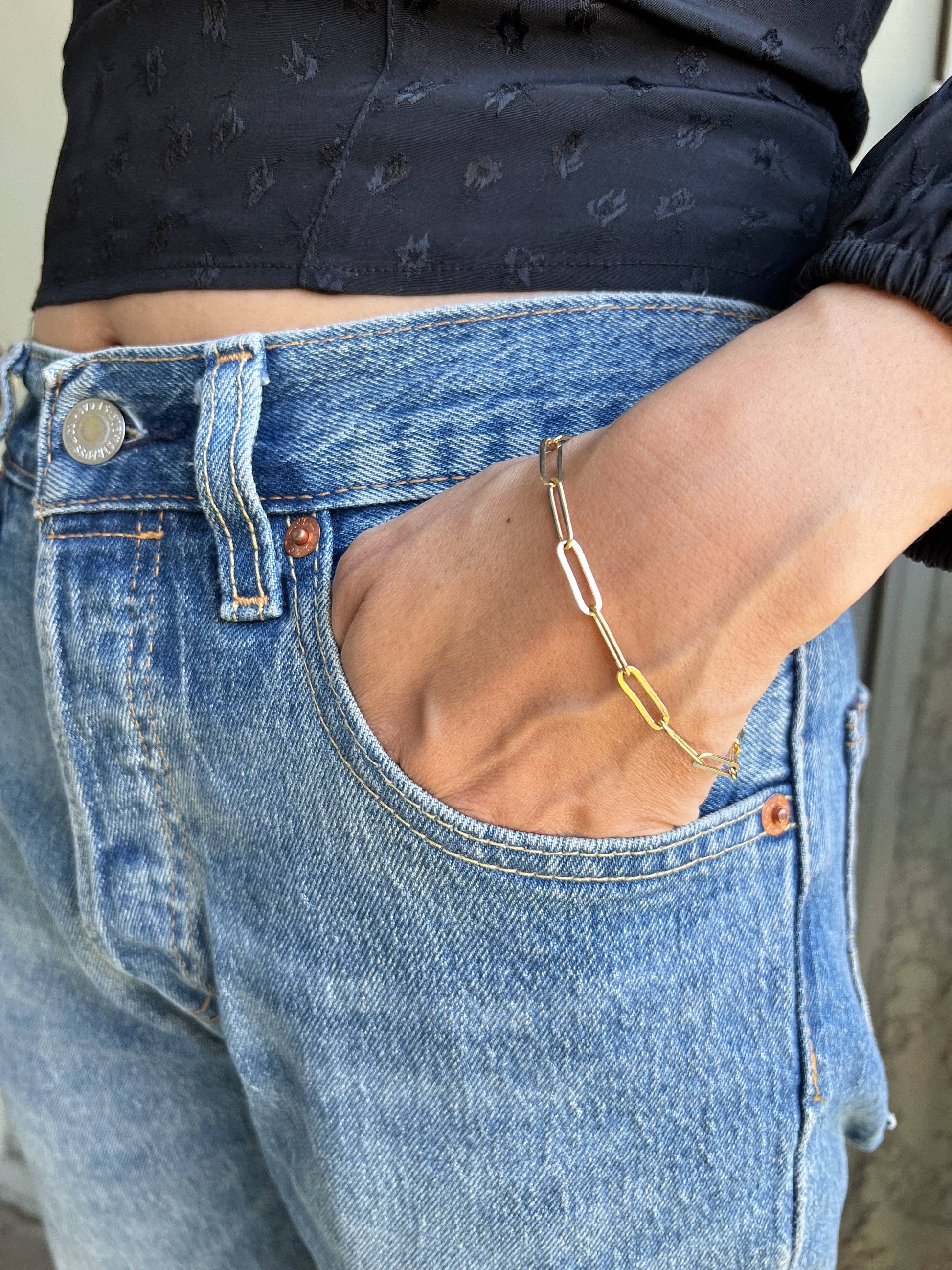 18k gold paperclip bracelet close up shot on a woman's wrist