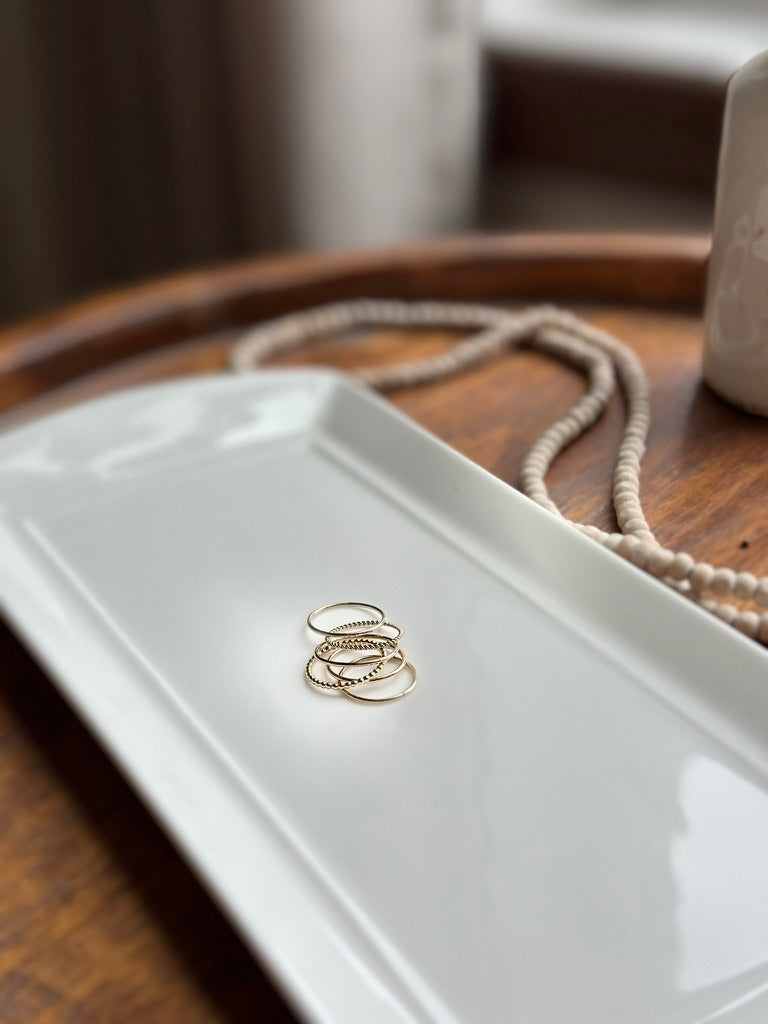Stack of 1mm wire stacking rings in 14k gold filled styled on white tray